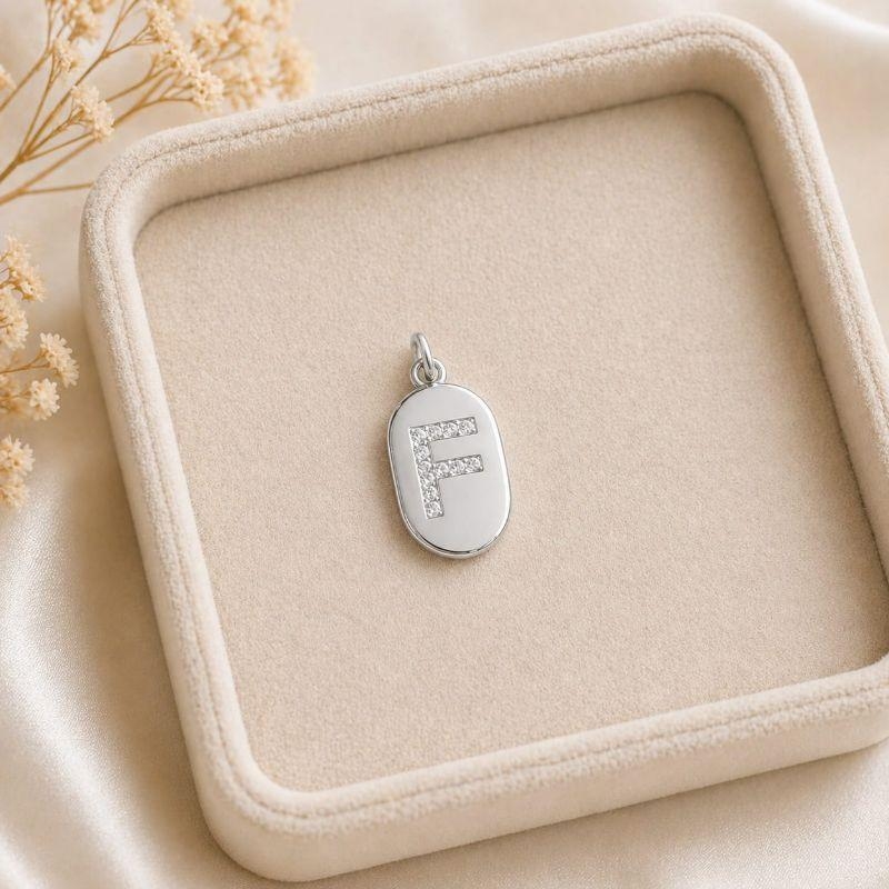 Pingente Letra Oval Cravejada F (19x10mm)