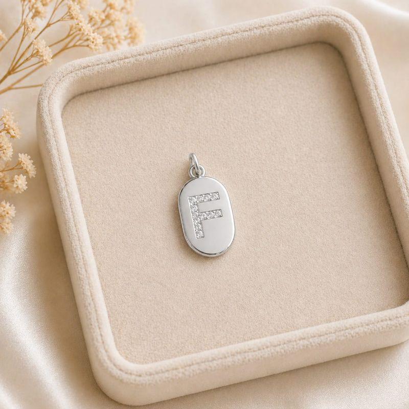 Pingente Letra Oval Cravejada F (19x10mm)