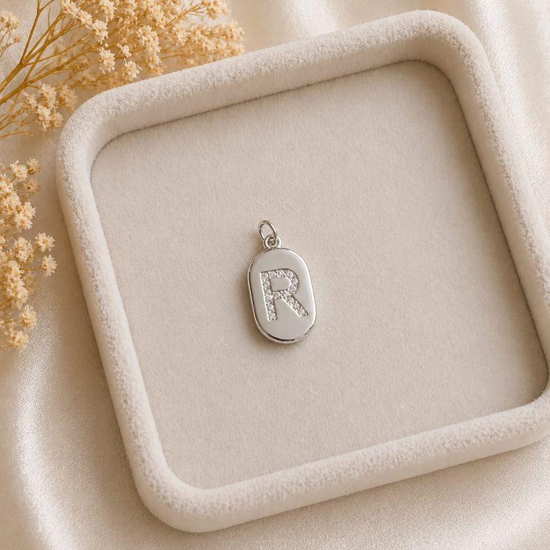 Pingente Letra Oval Cravejada R (19x10mm)